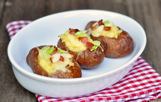 Klondike Rose twice baked potatoes with bacon green onions Greek yogurt almonds and cheese in a white dish on a checkered napkin