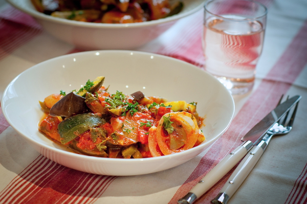 Julia Child's ratatouille recipe in a white bowl with a glass of rosé