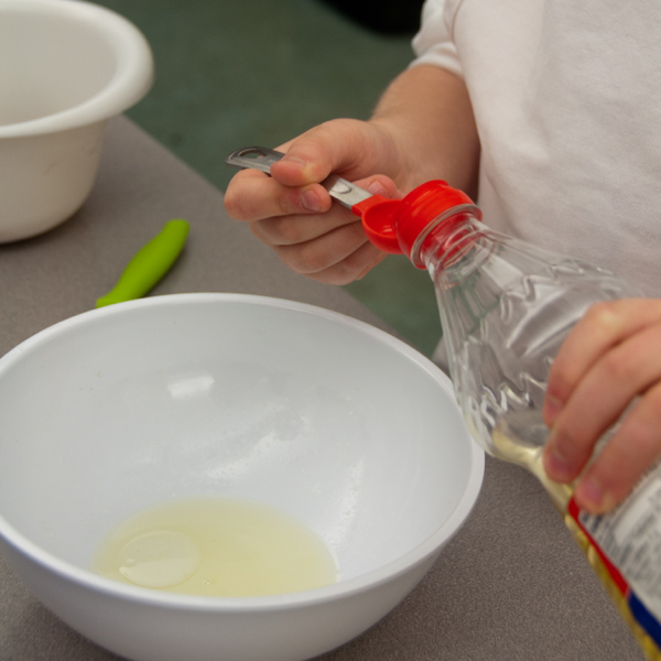 Kids measuring oil on eatlivetravelwrite.com