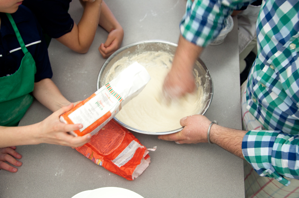 Kids adding flour to pizza dough on eatlivetravelwrite.com