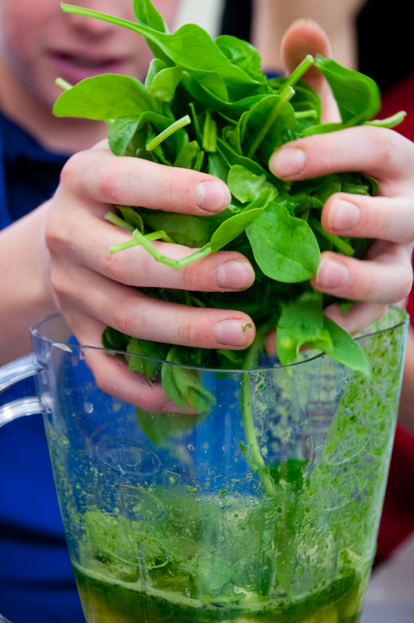 Kids making spinach smoothies on eatlivetravelwrite.com