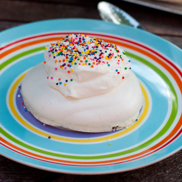 Pavlova topped with whipped cream and sprinkles on eatlivetravelwrite.com
