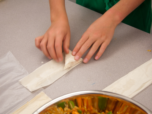 Kids folding sweet potato samosas from The Messy Baker on eatlivetravelwrite.com
