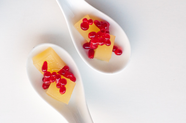 Orange jelly cubes in spoons topped with pomegranate caviar on eatlivetravelwrite.com