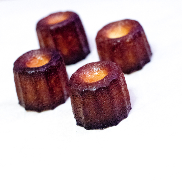 Side view of Caneles made in silicone moulds with butter coating on eatlivetravelwrite.com