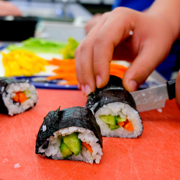 Kids cutting veggie sushi rolls with John Placko on eatlivetravelwrite.com