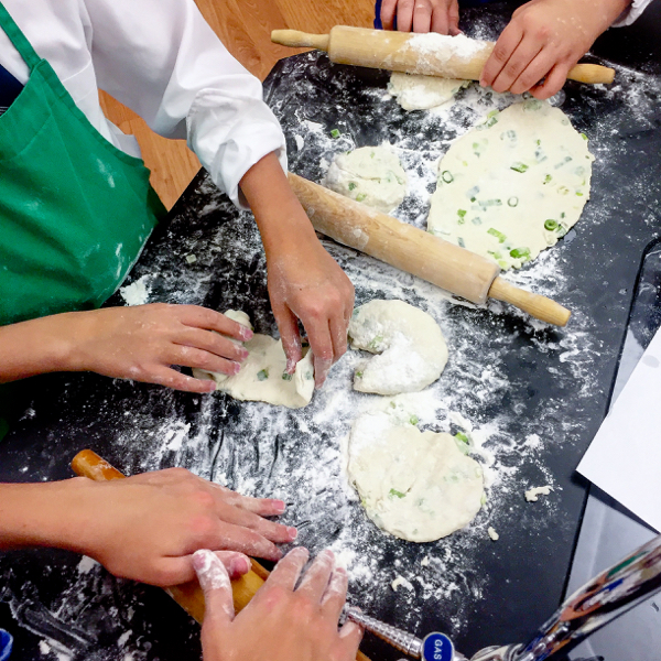 Little hands making green onion pancakes on eatlivetravelwrite.com