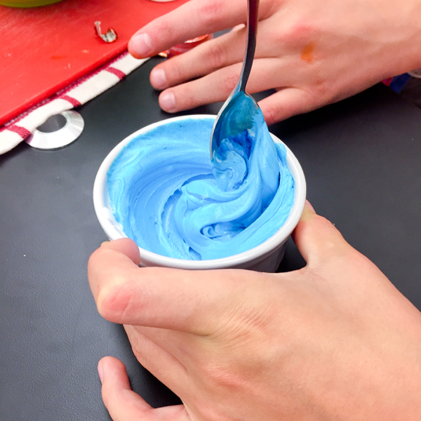 Mixing blue icing for decorating cookies on eatlivetravelwrite.com
