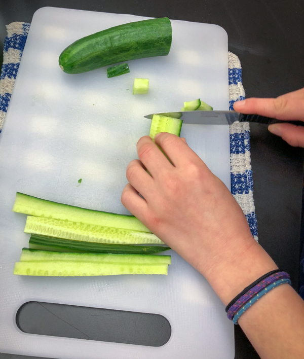Kids chop cucumbers to make Persian watermelon salad on eatlivetravelwrite.com