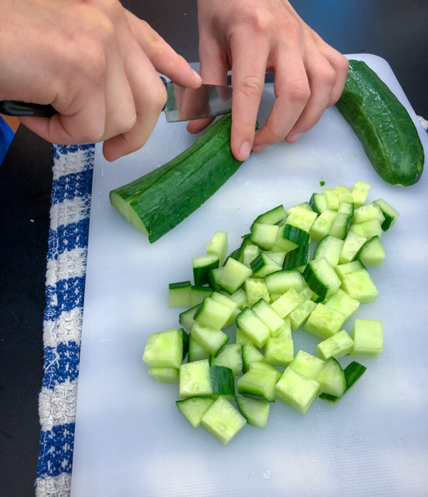 Kids dice cucumbers to make Persian watermelon salad on eatlivetravelwrite.com