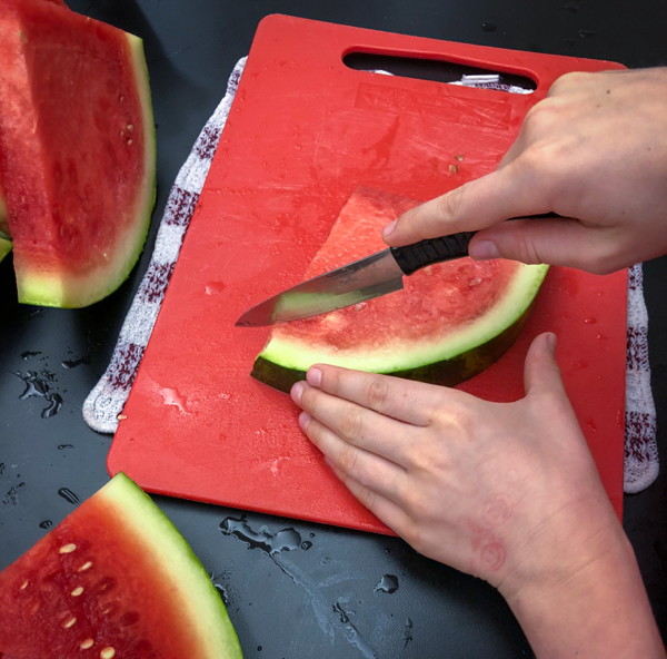 Kids dice watermelon to make Persian watermelon salad on eatlivetravelwrite.com