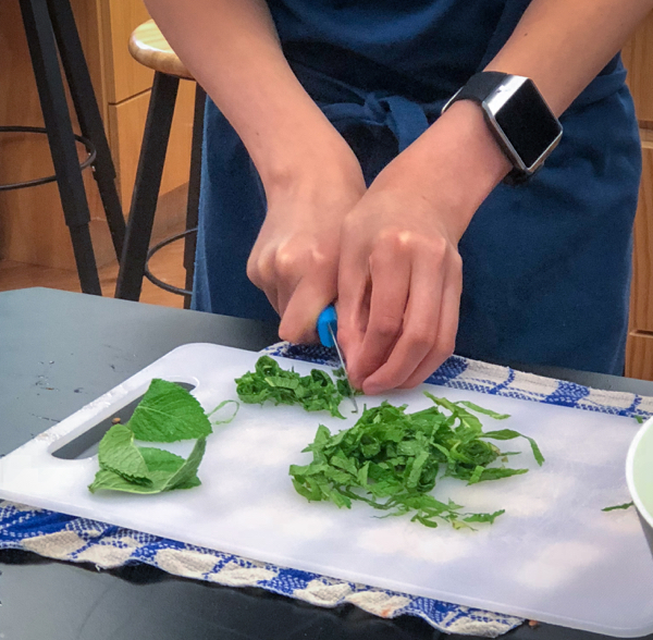 Kids chiffonade basil to make Persian watermelon salad on eatlivetravelwrite.com
