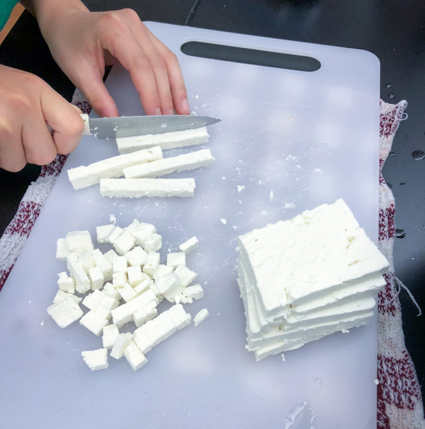 Kids slicig feta to make Persian watermelon salad on eatlivetravelwrite.com