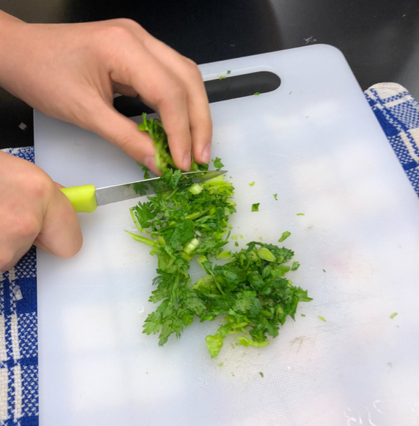 Kids chopping cilantro to make Persian watermelon salad on eatlivetravelwrite.com
