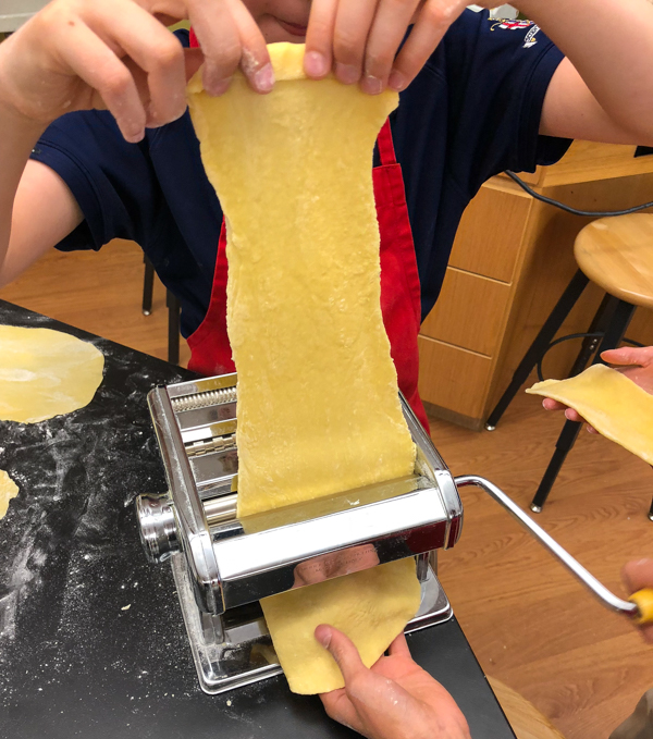 Kids using a pasta machine for pasta from scratch wth Emily Richards on eatlivetravelwrite.com