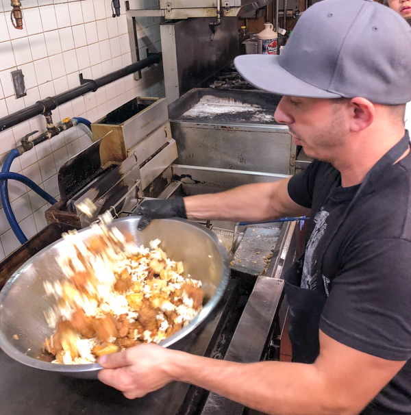 Matt Basile tossing popcorn chicken and waffle bits from Brunch Life at Lisa Marie with Matt Basile on eatlivetravelwrite.com