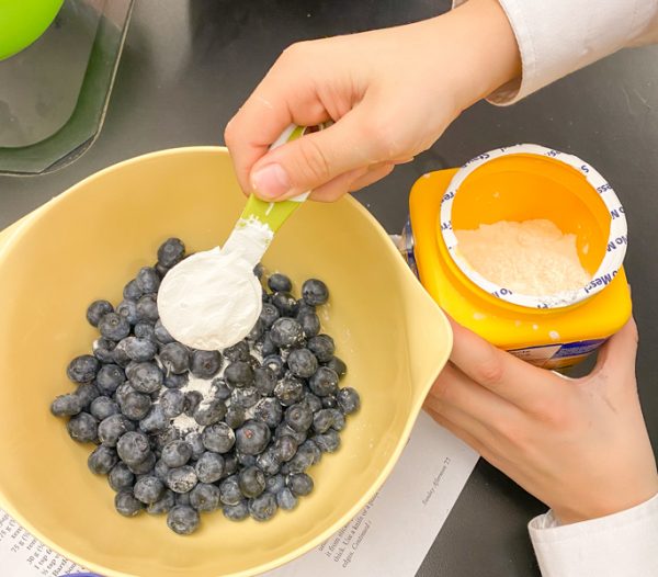 Adding cornstarch to fruit filling for mini pear blueberry cheesecake galettes from Duchess at Home on eatlivetravelwrite.com