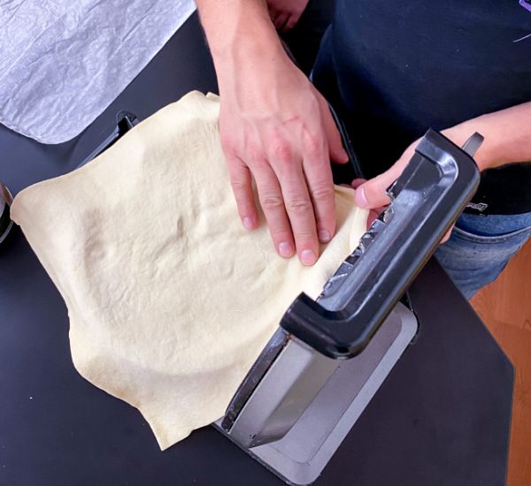 Placing the puff pastry in the waffle iron to make Apple Pie Waffles from Brunch Life with Matt Basile on eatlivetravelwrite.com