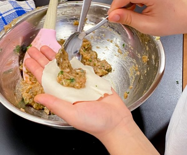 Filling dumpling wrappers to make potstickers with Vanessa Yeung on eatlivetravelwrite.com