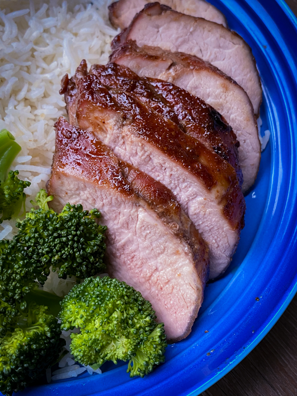 Red roast pork plated with broccoli and rice