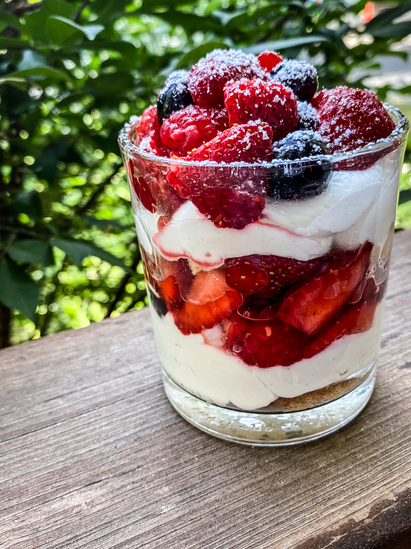 Individual serves of No-Bake Mixed Berry Cheesecake Trifle served in a small glass dish