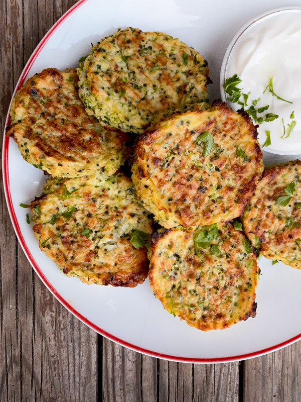 Cauliflower and Broccoli Cheesy Bites on a plate with sour cream.