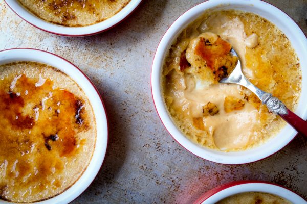 Pumpkin crème brûlée in small shalow ramekins on a baking sheet.