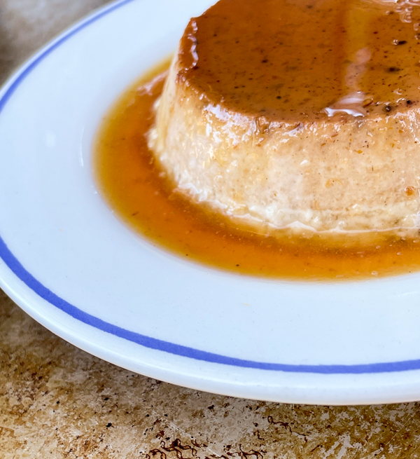 Pumpkin Crème Caramel on a white and blue plate.