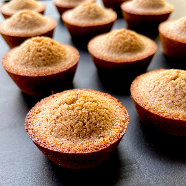 Speculoos financiers on a black serving plate.