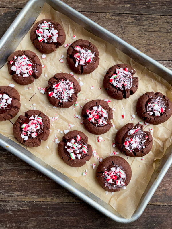 A tray of chocolate mint thumbprint cookies topped with crushed candy canes.