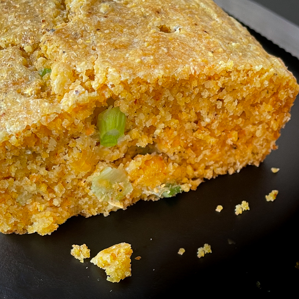 Interior of Dorie Greenspan's Whip-It-Up-Quick Cornbread from Baking with Dorie on a black serving tray.