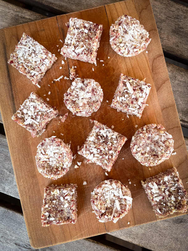 No-bake cranberry sunflower coconut bites on a cutting board.