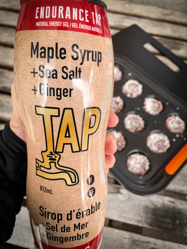 A bottle of Endurance Tap with No-bake cranberry sunflower coconut bites in the background.