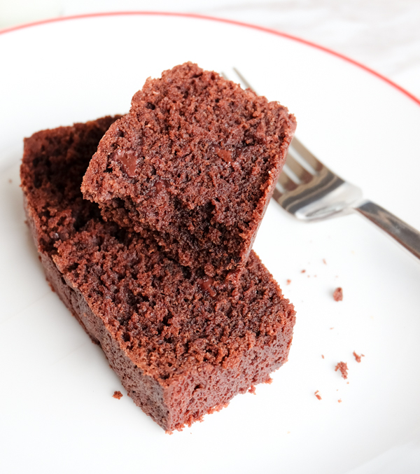 Slices of chocolate financier loaf cake on a plate.