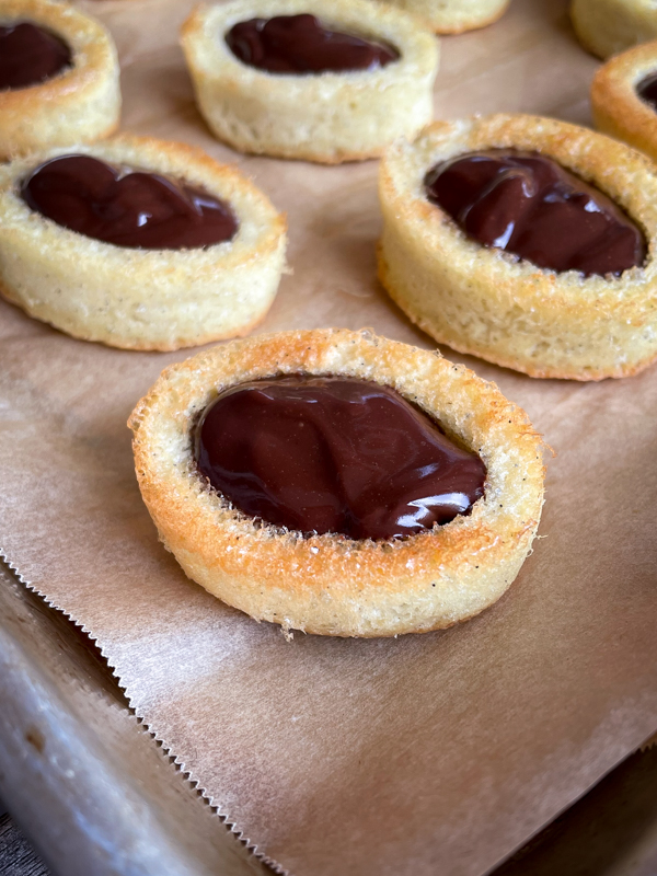 Close up of Chocolate barquette cookies on a baking tray lined with parchment.