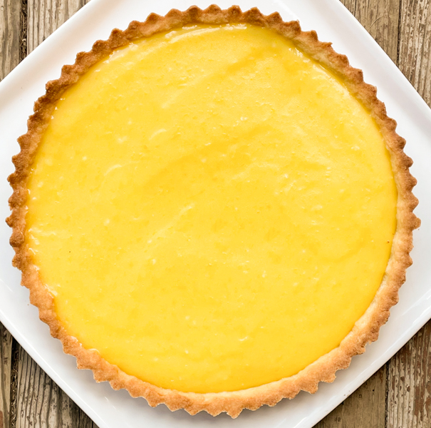 Whole Dorie Greenspan French Riviera Lemon Tart on a white plate.