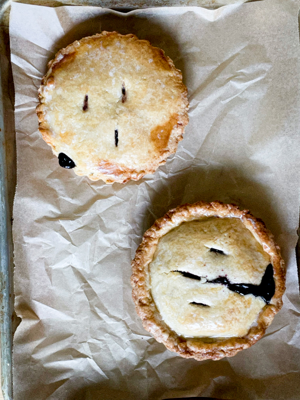 Dorie Greenspan's mini Blueberry Cherry Pie on a baking tray covered with parchment.