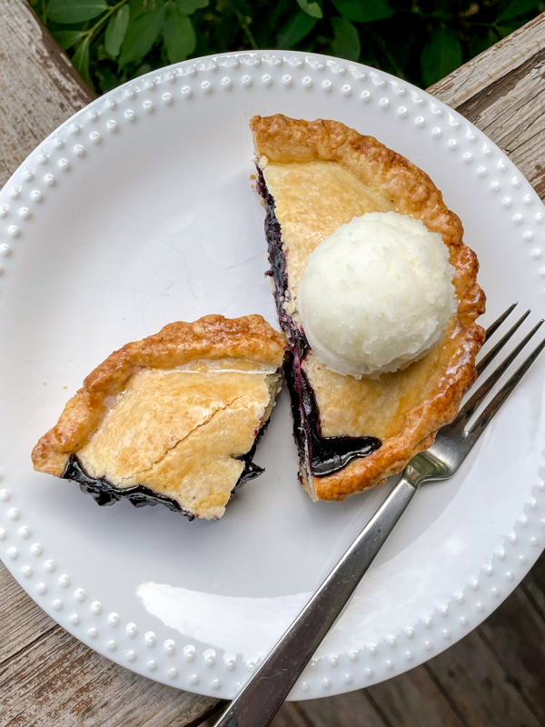 Dorie Greenspan's mini Blueberry Cherry Pie on a white plate with a fork.