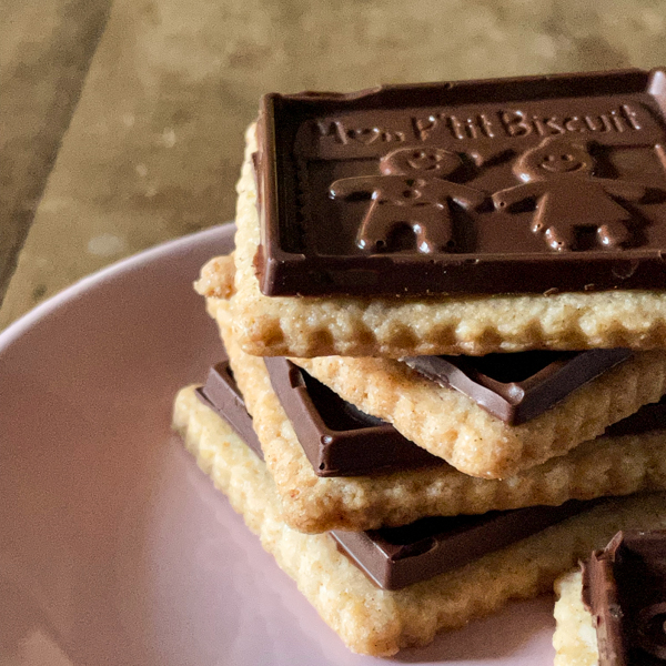 Close up of a stack of homemade petit écolier cookies on a pink plate.