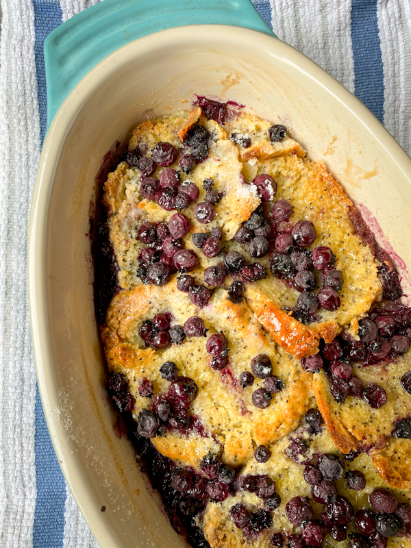 Scones Pudding from Baking with Dorie with blueberries in a baking dish on a striped tea towel.