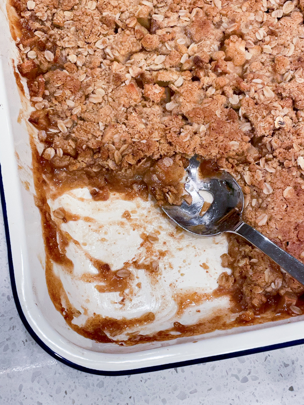 Caramel-Apple Crisp in a large baking dish with a slice taken out.