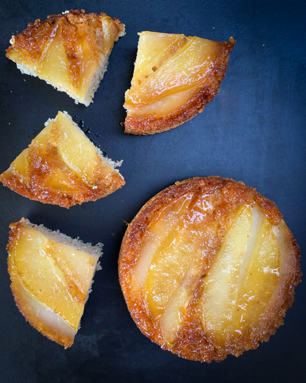 Small version of Caramel-Pear and Five-Spice Upside-Down Cake from Everyday Dorie on a dark serving platter.