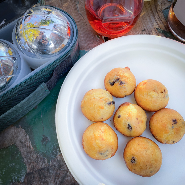 Goat Cheese Bites from Baking with Dorie on a white plate next to a set of boules and some wine.