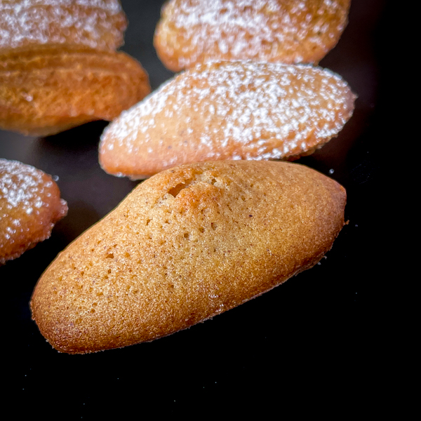 Gingerbread madeleines on a black serving dish.