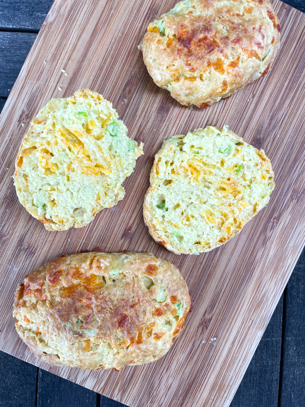 Dorie Greenspan's Cheddar Scallion Scones sliced open on a wooden serving board.