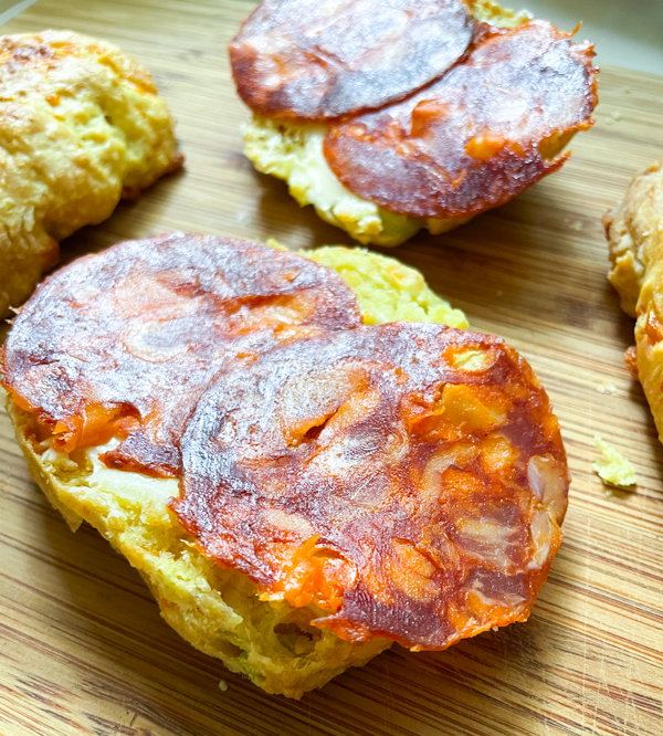 Dorie Greenspan's Cheddar Scallion Scones with chorizo on a wooden serving board.