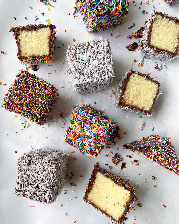 Dorie Greenspan's lamingtons with coconut and sprinkle coating on a baking tray covered in parchment.