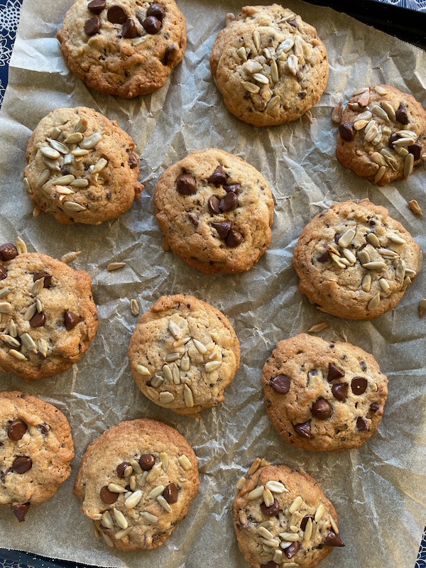 Copenhagen Rye Cookies with Chocolate, Spice and Seeds on a baking tray covered in parchment.