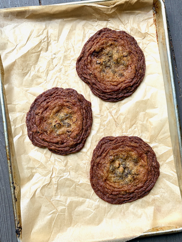 Maple-Bacon Chocolate Chip Cookies on a parchment-lined baking sheet.