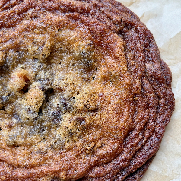 close up of Maple-Bacon Chocolate Chip Cookies on a parchment-lined baking sheet.